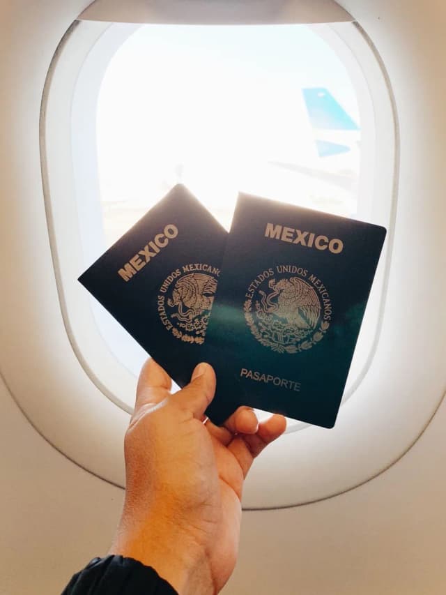 Passeports mexicains tenus devant le hublot d'un avion avant l'atterrissage à Cancún
