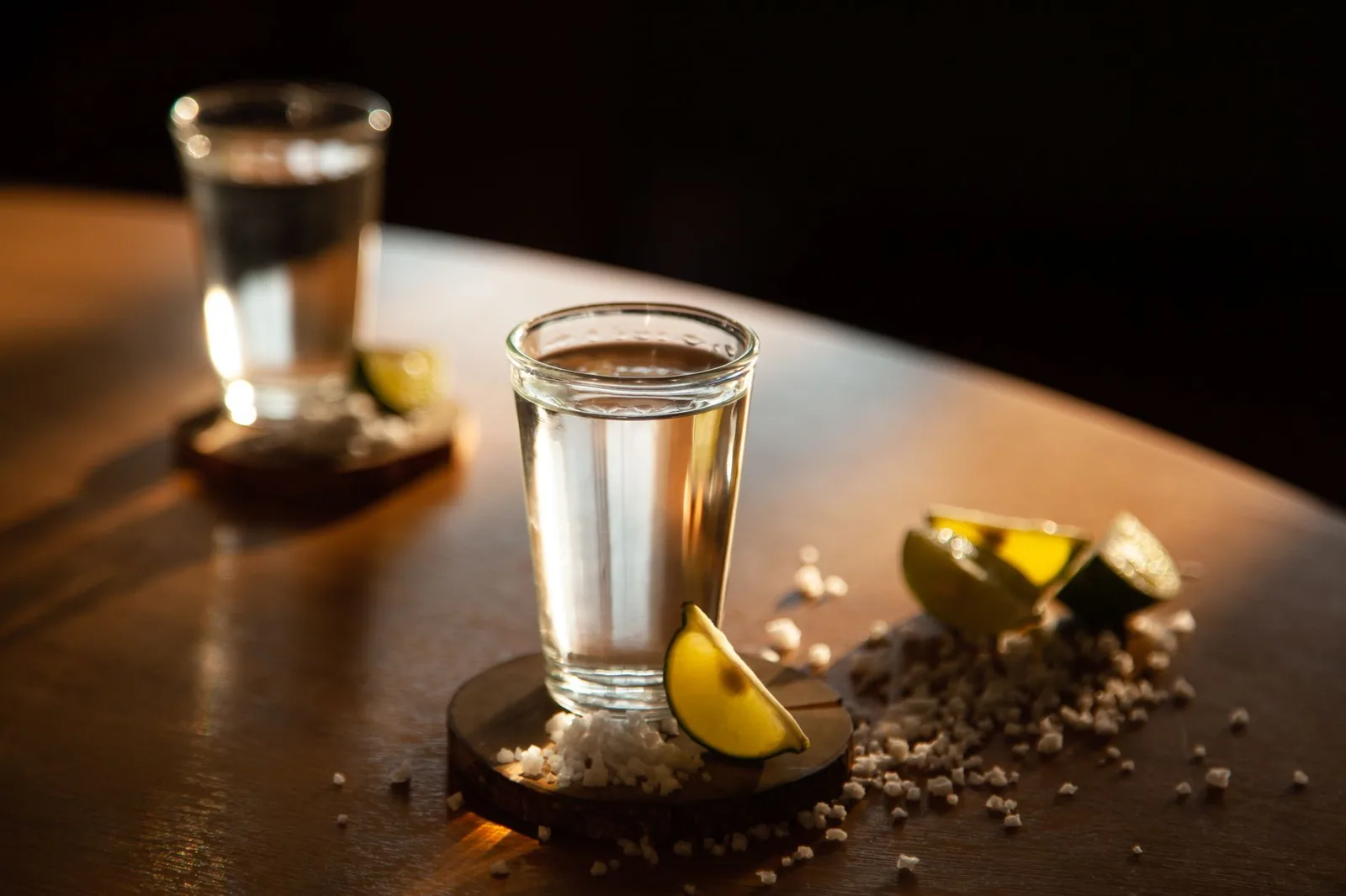 Verres de tequila et rondelles de citron vert sur un comptoir en bois au Mexique