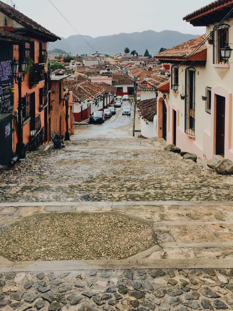 Rue pavée bordée de façades colorées à San Cristóbal de las Casas, avec les montagnes du Chiapas en arrière-plan