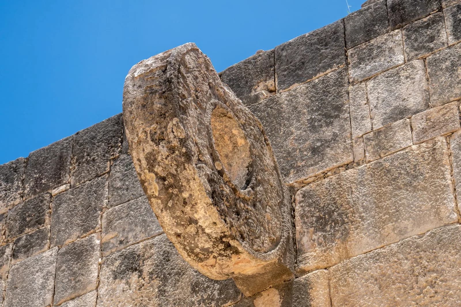 Anneau de pierre sculpté fixé en hauteur sur le mur du grand jeu de balle de Chichén Itzá, au Yucatán