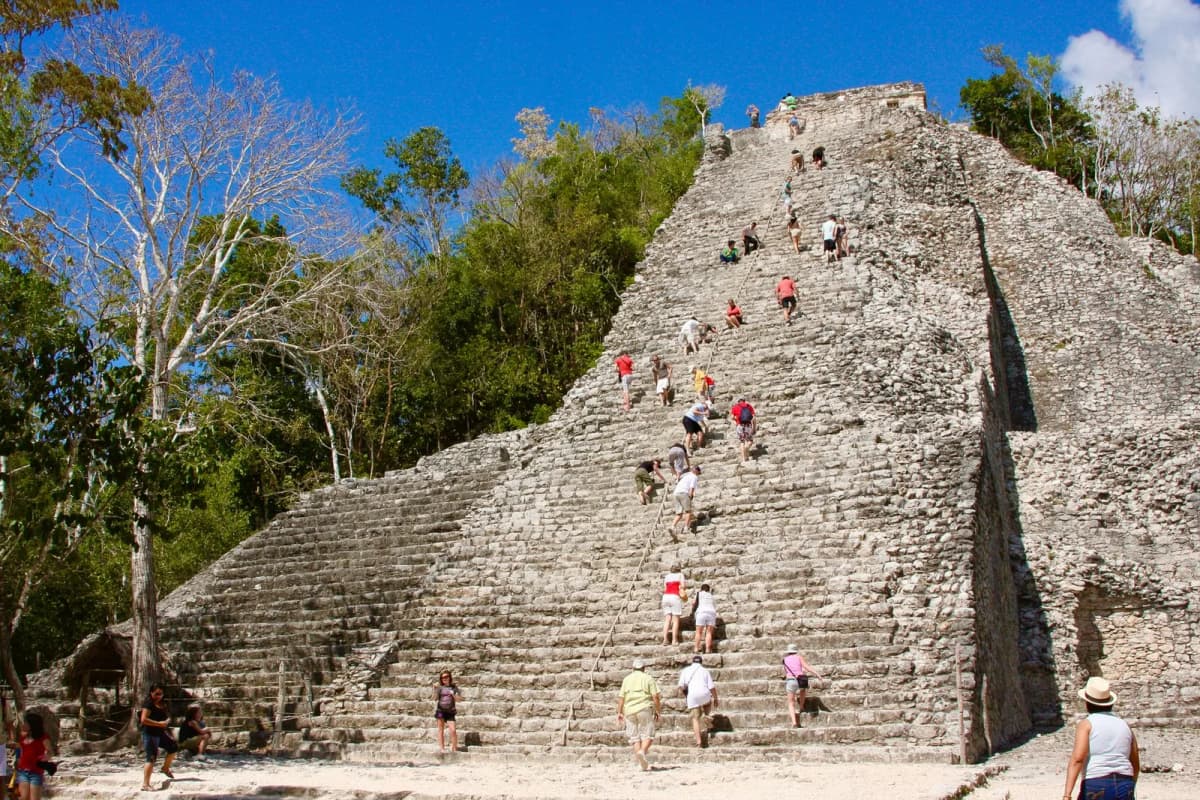 Visiteurs grimpant la pyramide Nohoch Mul de Cobá par l'escalier central