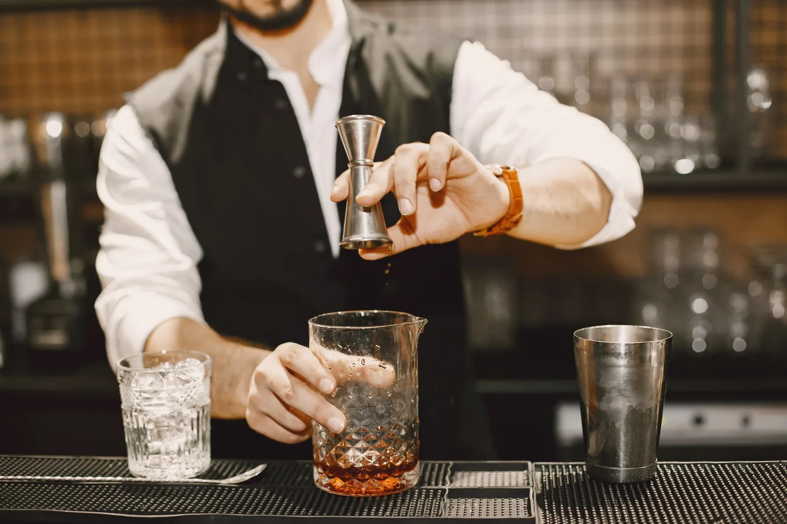 Barman préparant des cocktails sur un comptoir de club, à l'image de l'open bar du Coco Bongo