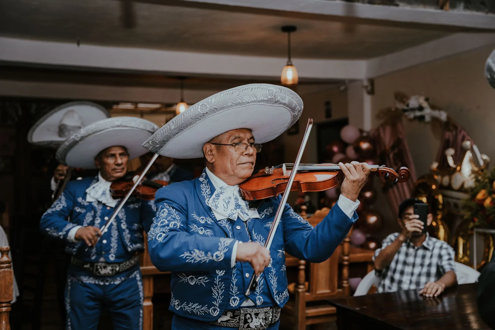 Musiciens mariachi en costume de charro bleu et sombrero, jouant du violon au Mexique