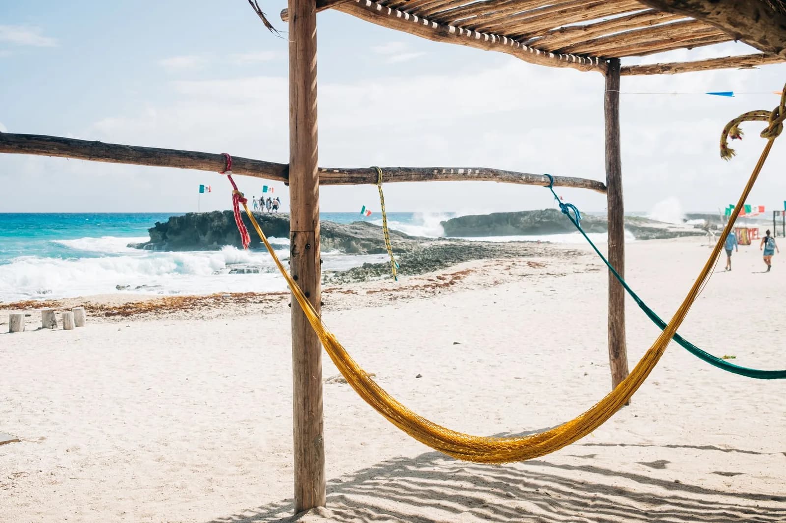 Hamacs sous une palapa face aux vagues et aux rochers de la côte est sauvage de Cozumel