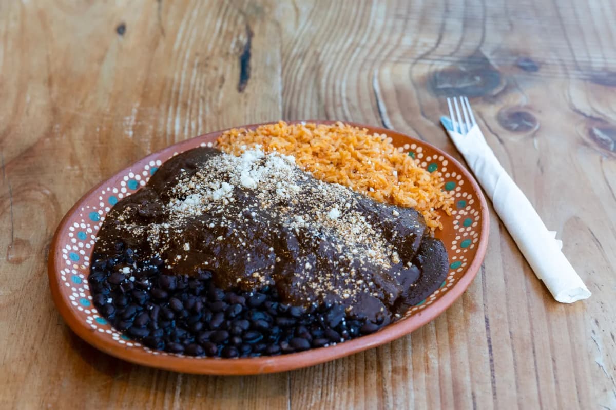 Assiette de mole poblano servie avec du riz rouge et des haricots noirs, Mexique