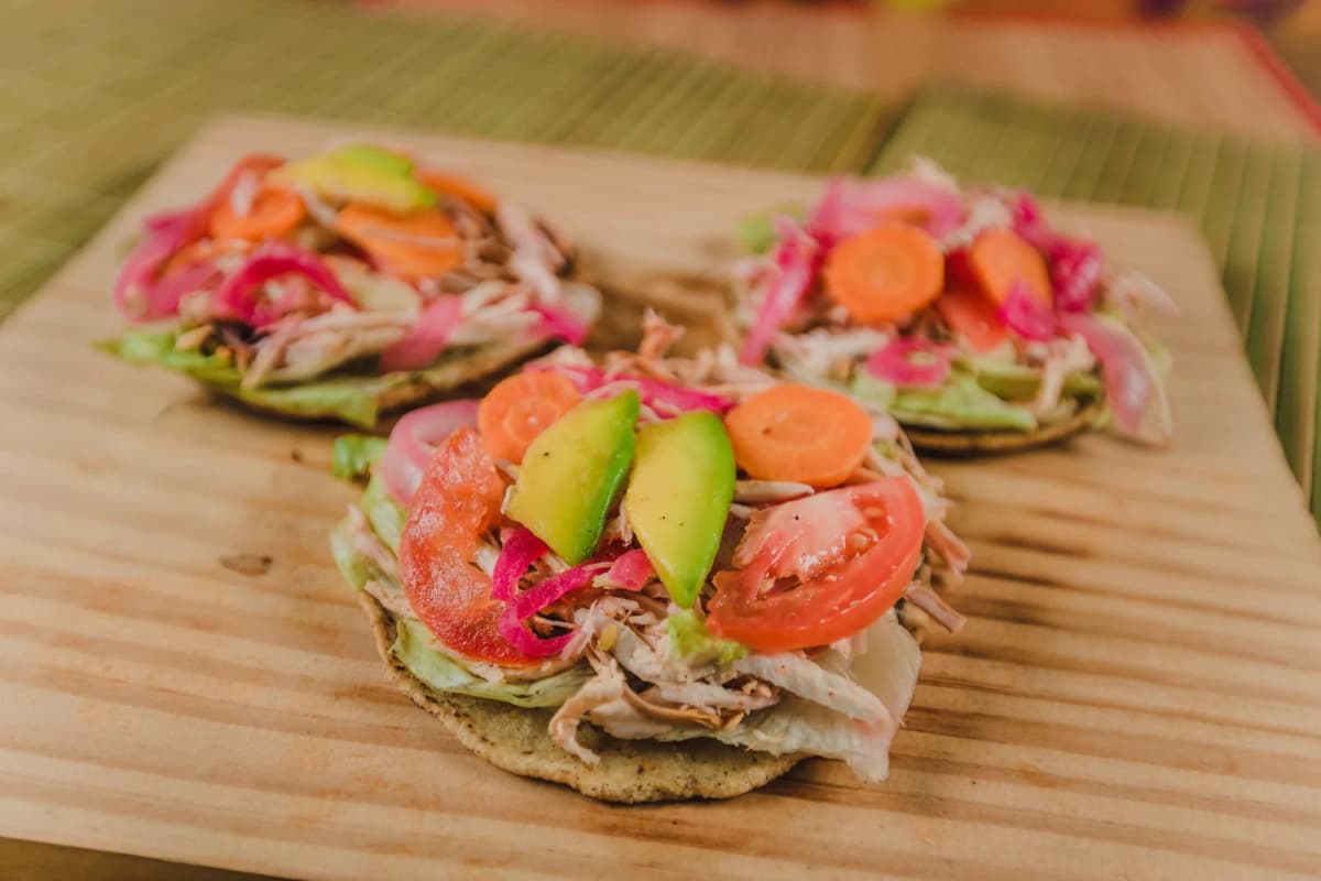 Tostadas mexicaines garnies de poulet effiloché, oignon rouge mariné et avocat