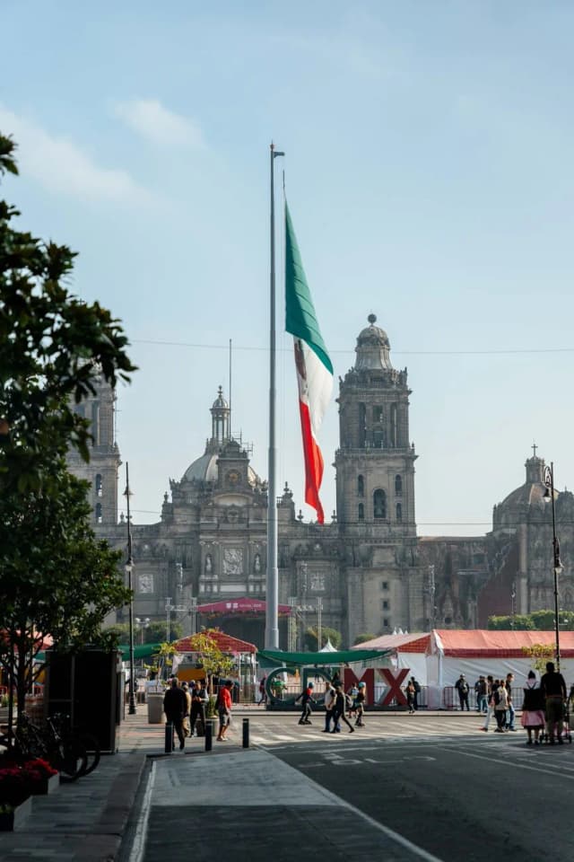 Drapeau monumental du Mexique sur sa hampe au centre du Zócalo de Mexico, devant la cathédrale métropolitaine