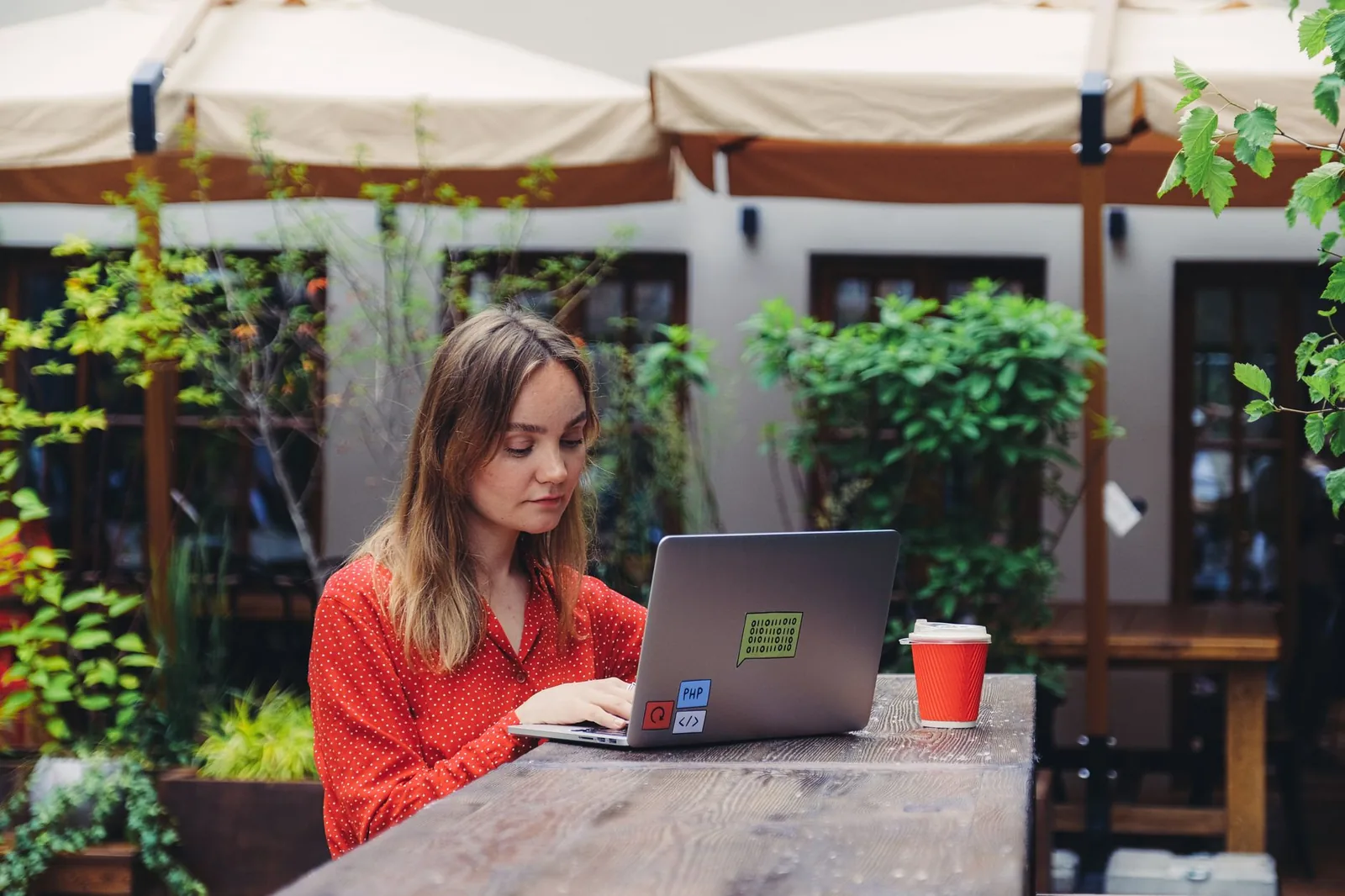 Nomade numérique travaillant sur son ordinateur portable en terrasse d'un café, mode de vie télétravail au Mexique