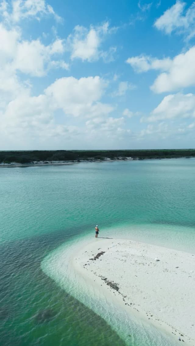 Banc de sable blanc émergeant d'une eau turquoise peu profonde à la pointe d'Isla Holbox
