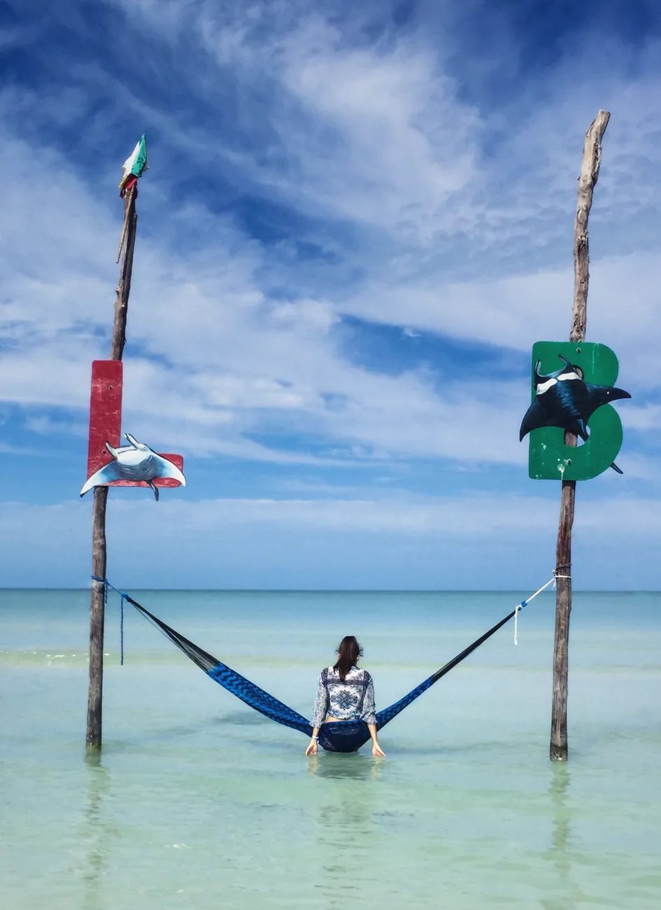 Hamac tendu entre deux poteaux de bois dans l'eau peu profonde d'une plage d'Isla Holbox, au Mexique
