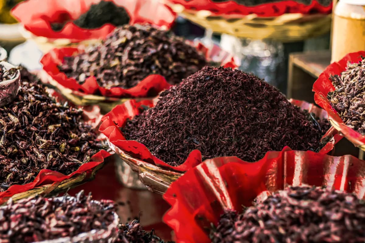 Chapulines grillés en tas dans des corbeilles à bord rouge sur un étal de marché mexicain