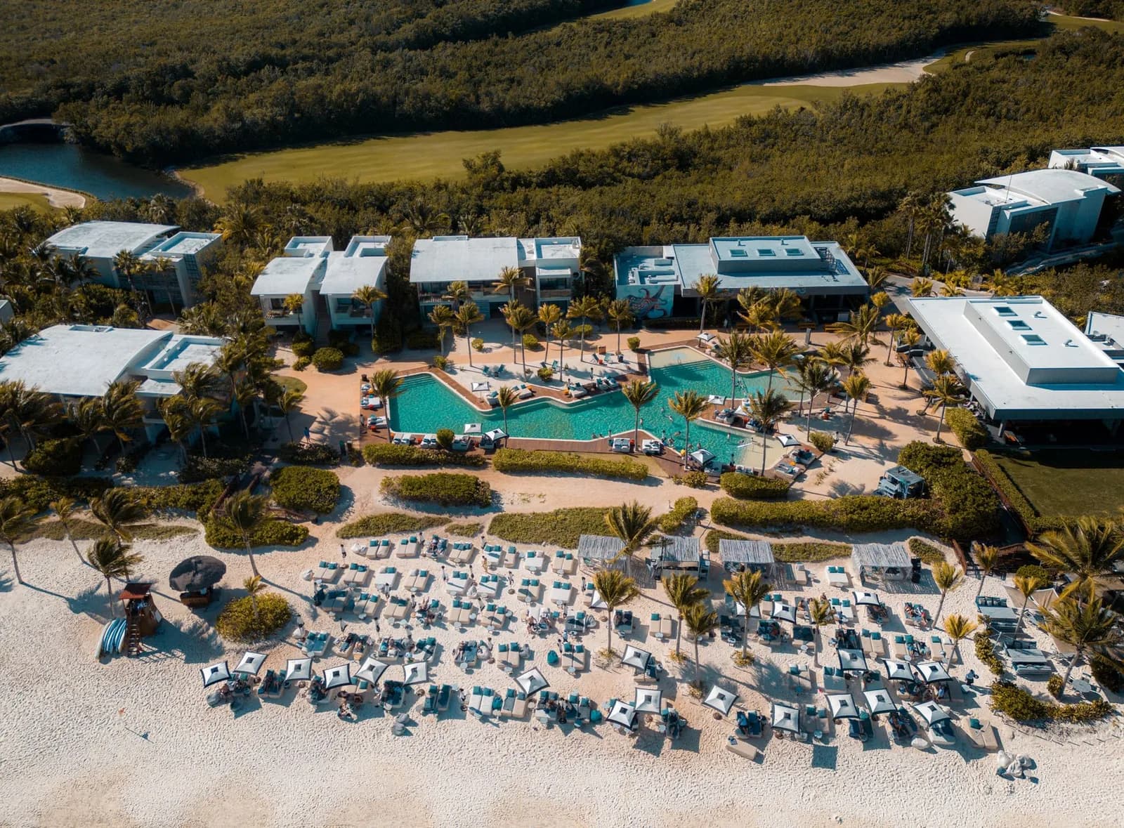Resort en bord de mer avec piscines et transats sur la plage à Playa del Carmen