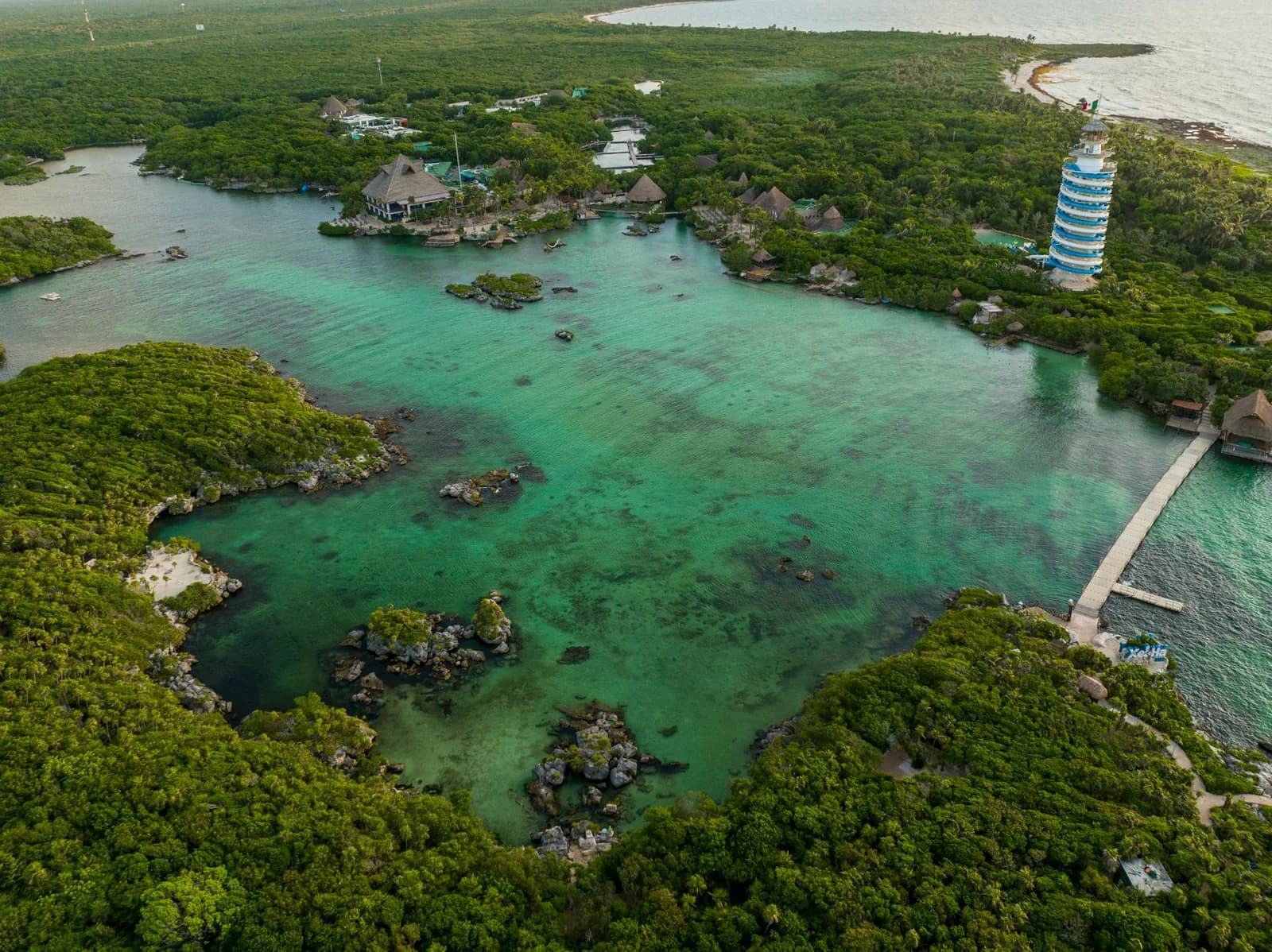 Vue aérienne de la crique de Xel-Há, de sa mangrove et de son phare rayé, près de Tulum