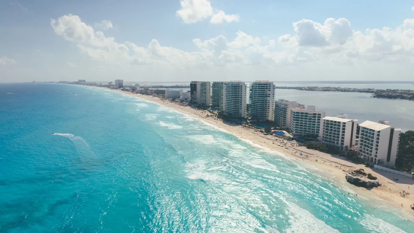 Vue aérienne de la zone hôtelière de Cancún, avec la façade est face aux vagues des Caraïbes et la lagune à droite