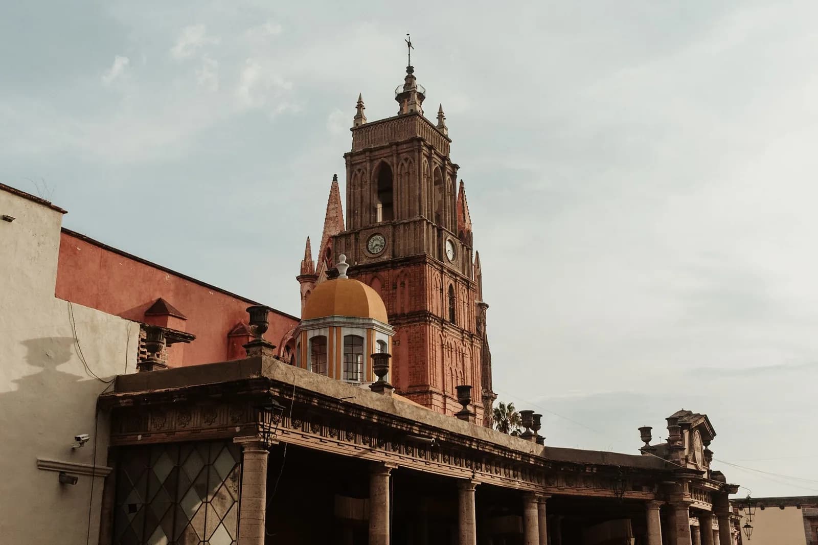 Tour néogothique rose de la Parroquia de San Miguel Arcángel dominant les toits de San Miguel de Allende, au Mexique
