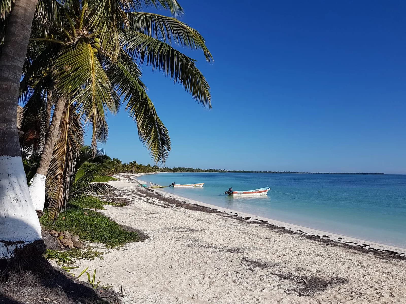 Plage de sable blanc et barques de pêche à Punta Allen, dans la réserve de Sian Ka'an