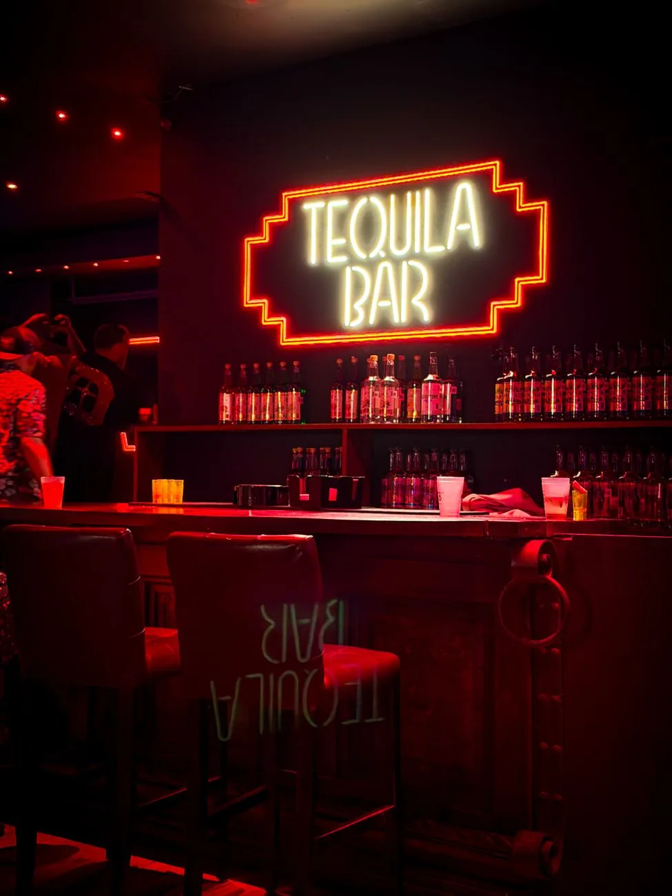 Bar à tequila éclairé au néon rouge dans un établissement de nuit de Cancún, Mexique