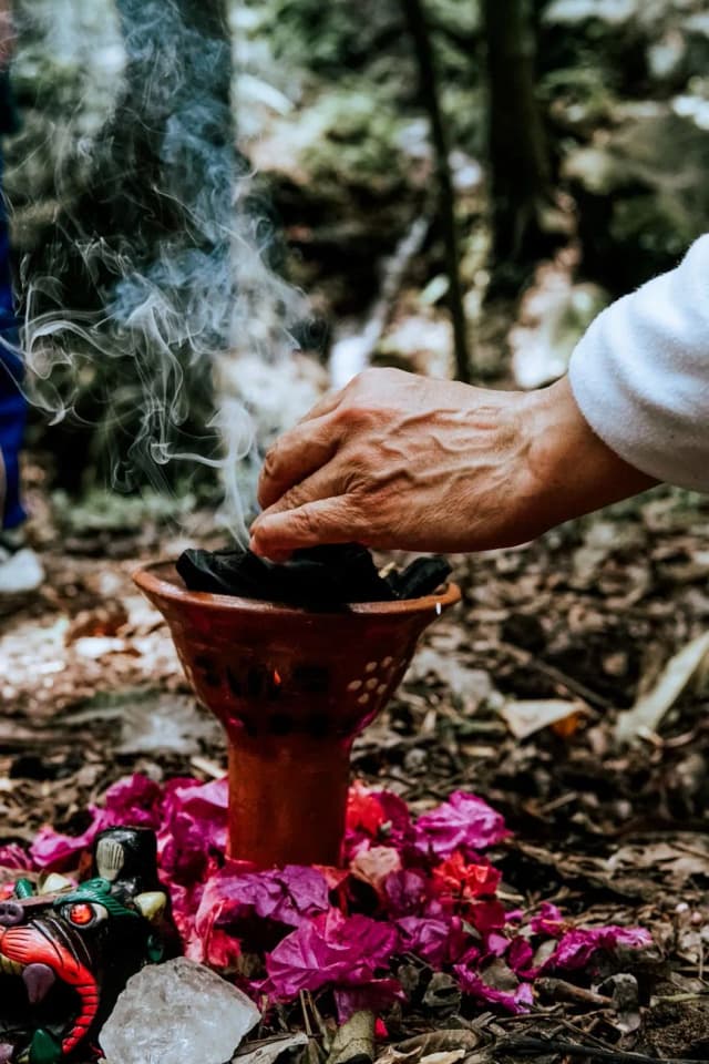 Encensoir de copal fumant posé sur des pétales de fleurs lors d'un rituel mexicain avant un temazcal