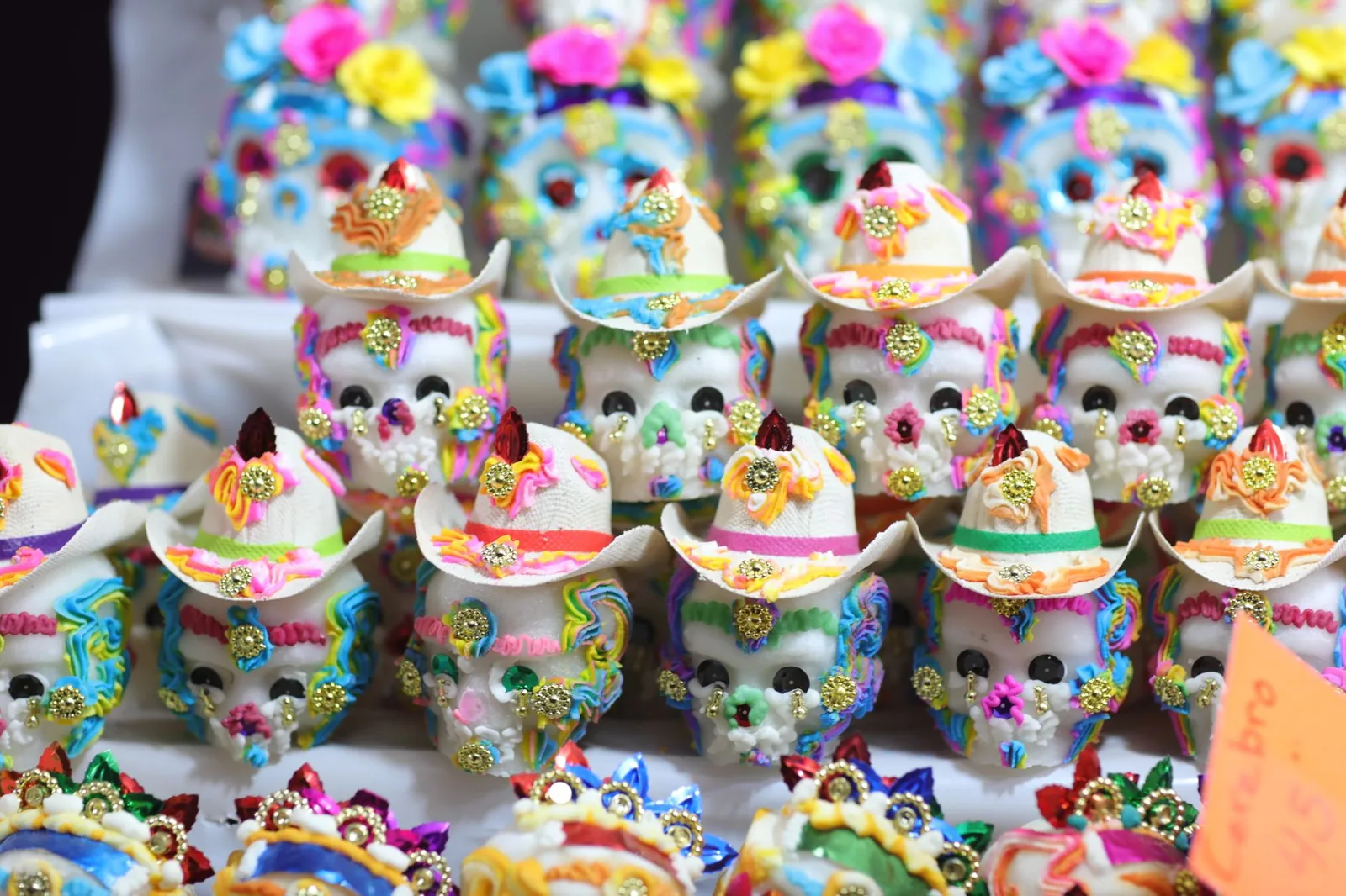Crânes en sucre colorés (calaveritas de azúcar) décorés de glaçages et de petits chapeaux sur un marché mexicain