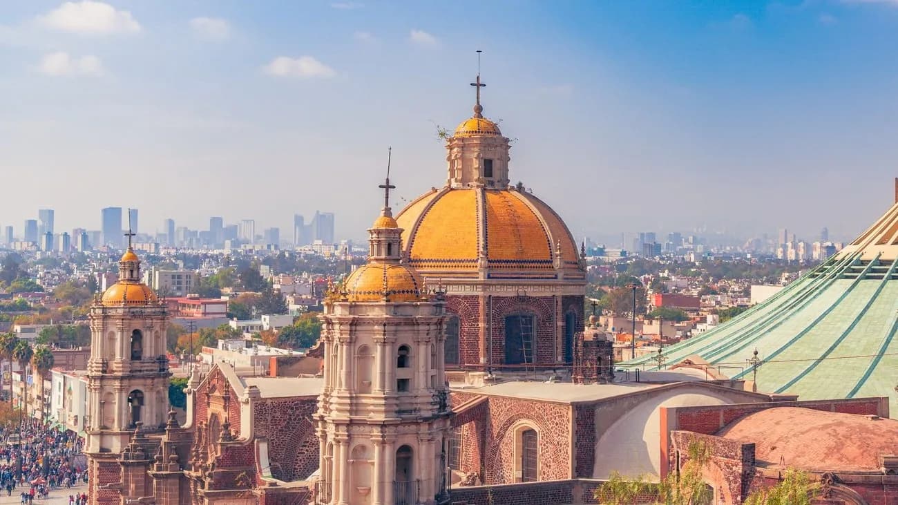 Façade baroque, tours et dôme orange de l'ancienne basilique de Guadalupe au pied du Tepeyac, à Mexico, avec la nouvelle basilique à droite