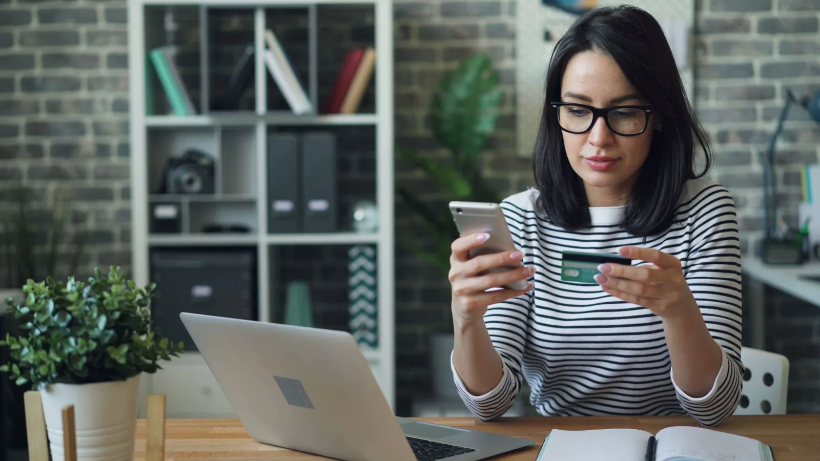 Voyageuse qui règle un paiement en ligne avec sa carte bancaire et son smartphone